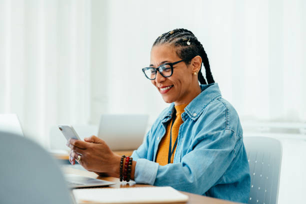 istock Confident mature businesswoman using a smartphone in a spacious, light-filled office 2176623793