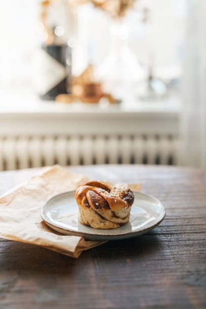 istock Freshly baked cinnamon bun on rustic wooden table 2176624108