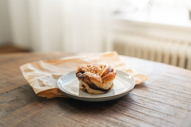 istock Freshly baked cinnamon bun on rustic wooden table 2176624125