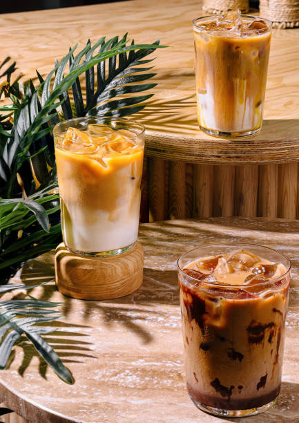 istock Three iced coffee drinks sitting on a cafe table in the sun 2176625554