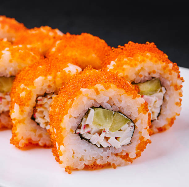istock California sushi rolls covered with tobiko red caviar lying on white plate 2176625621
