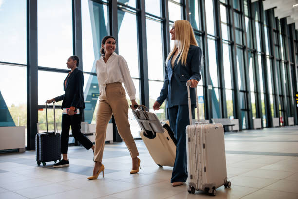 istock Two businesswomen talking while moving through an airport terminal 2176626083