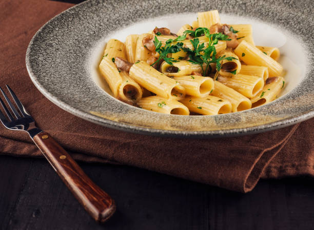 istock Pasta dish with mushrooms and parsley on wooden table 2176626897