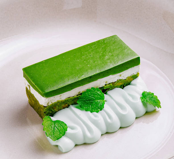 Matcha green tea cake with cream cheese and pistachio paste on white plate