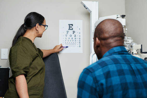 istock Optometrist Assisting Patient with Eye Chart in Professional Examination Room 2176629536