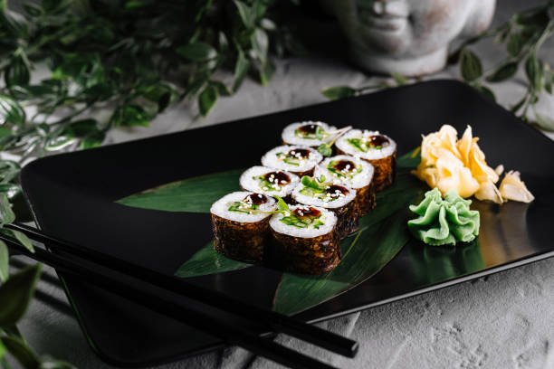 istock Delicious sushi rolls served on black plate with wasabi and ginger 2176631053