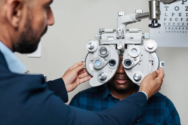 istock Optometrist Conducting Eye Examination with Phoropter on Patient in Modern Optometry Office 2176631642