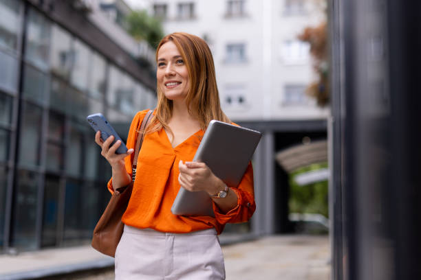 istock Businesswoman using her phone while navigating the city streets 2176632963
