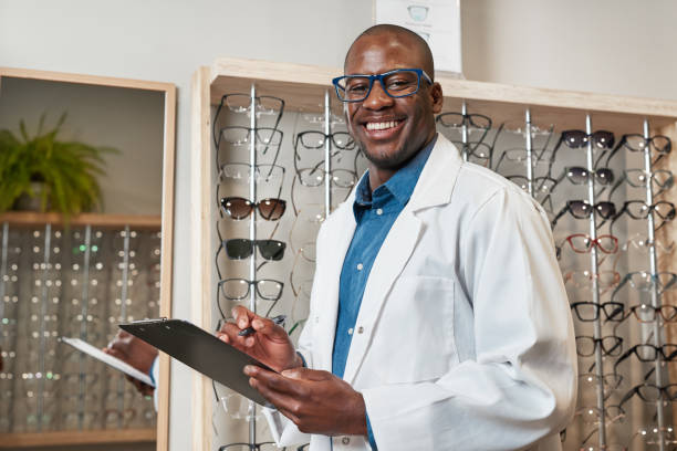 istock Smiling Optometrist in White Coat Holds Clipboard Inside Eyewear Store 2176635687