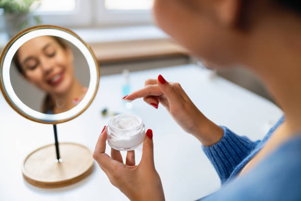 istock Young woman applying a face cream in front of the mirror 2176641149