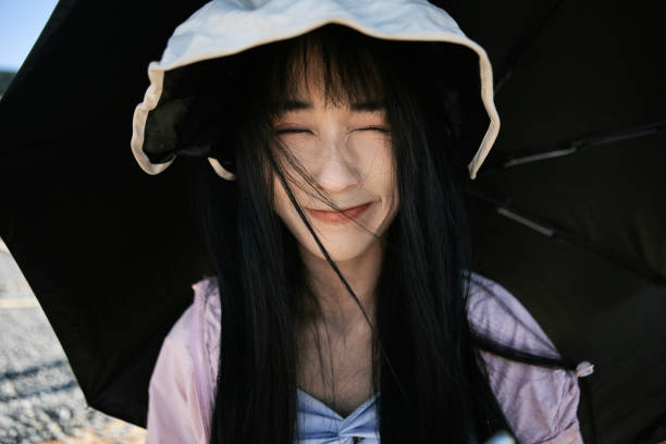The girl under the parasol and sun hat, close-up cute expression