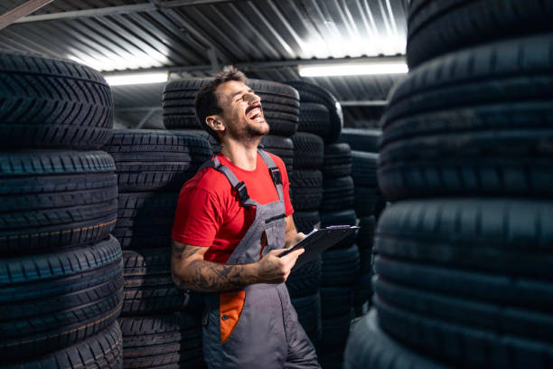 istock Smiling warehouse worker arranging new tires arrival. 2176648909