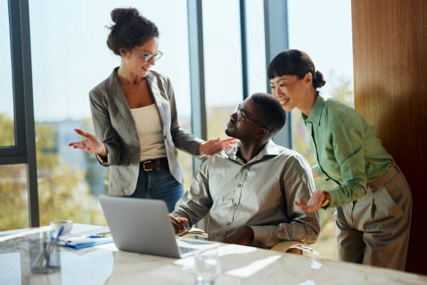 istock Diverse business team talking while working on laptop in the office. 2176650199