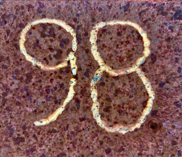 The number 98 arc welded into a steel bench.