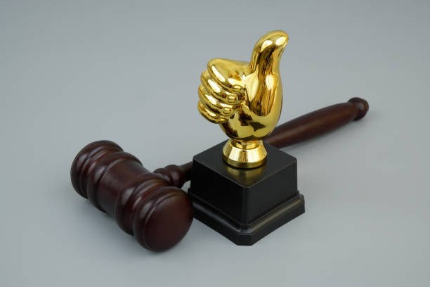 Best attorney or lawyer concept. Judge gavel with thumbs up cup on gray background.