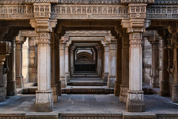 istock Majestic view through intricately carved sandstone pillars leading deep into the stepwell's core, showcasing symmetrical architecture and ancient craftsmanship. 2176653992