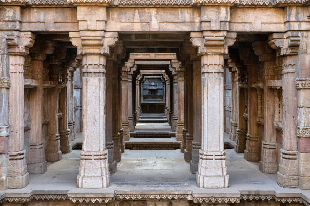 istock Majestic view through intricately carved sandstone pillars leading deep into the stepwell's core, showcasing symmetrical architecture and ancient craftsmanship. 2176654076