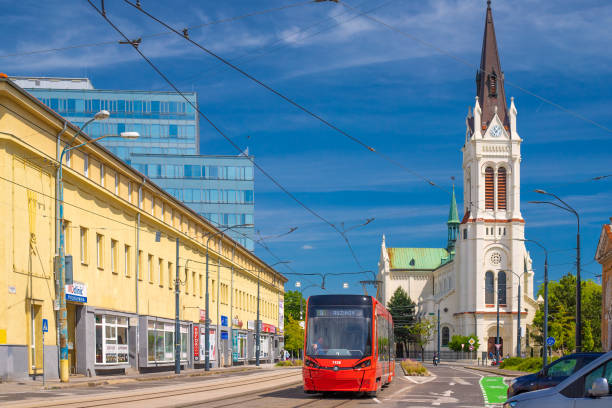 Bratislava, Slovakia - 5 May 2024: A red tram passes by the Blumental Church