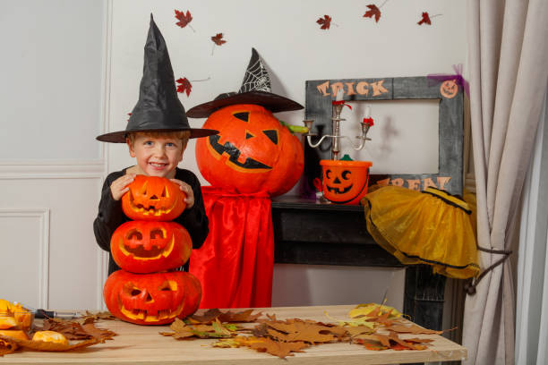 istock Smiling kid boy in a witch hat with Halloween jack o lanterns 2176655887