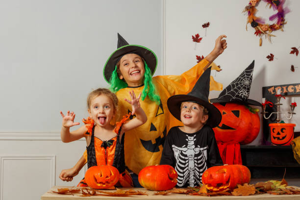 istock Kids in witch and skeleton costumes having fun with pumpkins 2176655900