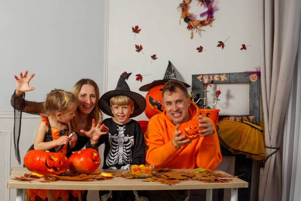 istock Happy family with creative pumpkin carving make spooky grimaces 2176655902