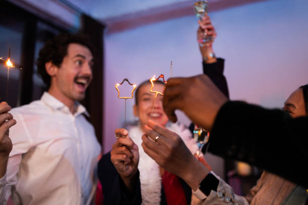 istock Happy friends lighting sparklers and enjoying a celebration 2176658196