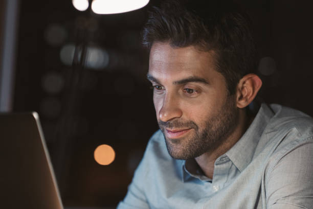 istock Smiling businessman working online in his office at night 2176663097