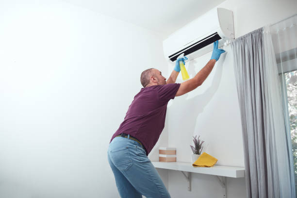 istock Man cleaning and maintaining air condition unit at home. 2176664447