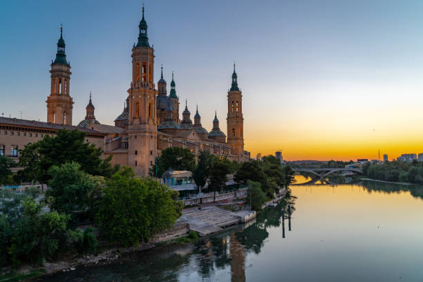 Zaragoza Cathedral and Ebro River. Spectacular orange sunset reflecting. Famous travel destination in Spain. Sunset point.