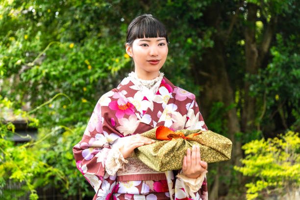 istock A woman in a kimono holding a gift 2176673385