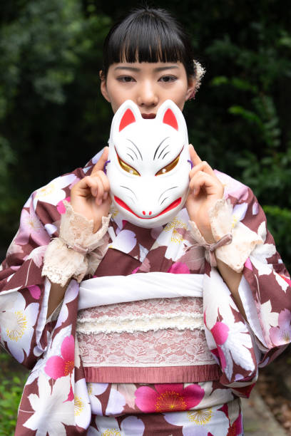 istock A woman in a kimono posing with a fox mask 2176673608