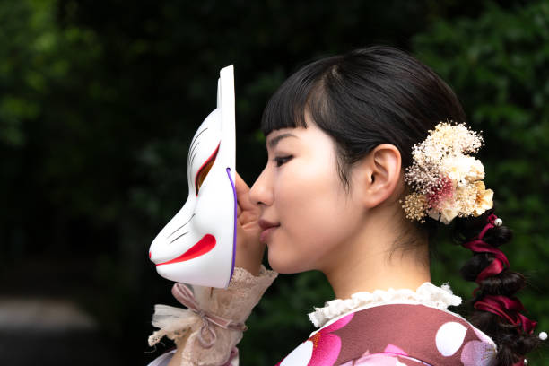 istock A woman in a kimono posing with a fox mask 2176673660