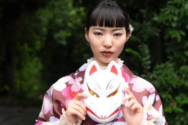 istock A woman in a kimono posing with a fox mask 2176675270