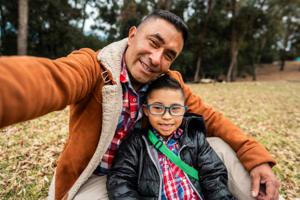 istock Father taking a selfie with son with down syndrome outdoors - camera point of view 2176675563