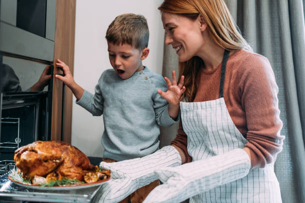 istock Mother and son preparing turkey for Thanksgiving day. 2176675649