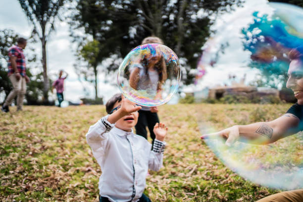 Boy with down syndrome playing soap bubbles outdoors