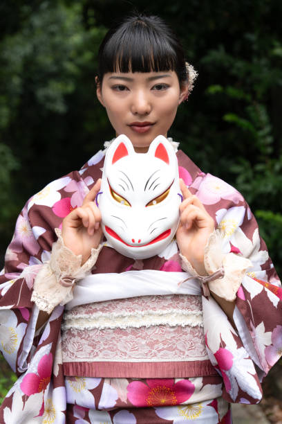 istock A woman in a kimono posing with a fox mask 2176677323