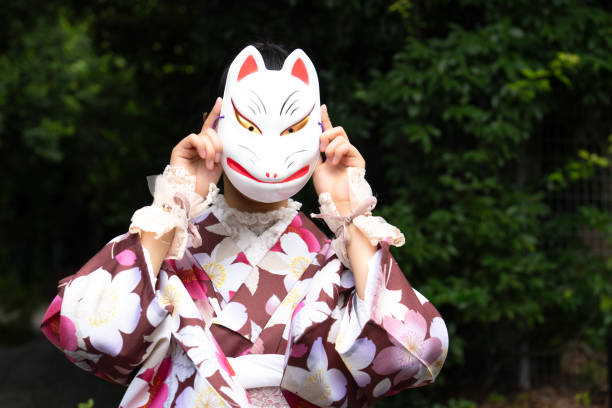 istock A woman in a kimono posing with a fox mask 2176677754