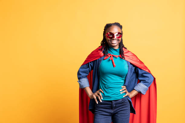 istock Girl portraying superhero with red cape, hiding identity, studio background 2176687164