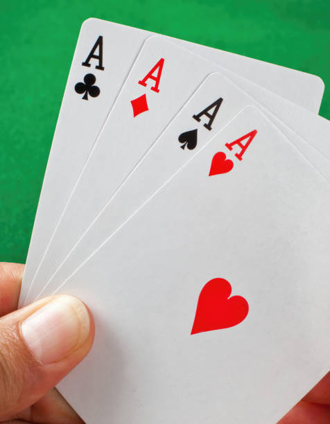 istock Gambler holding four aces playing cards on green background 2176687347