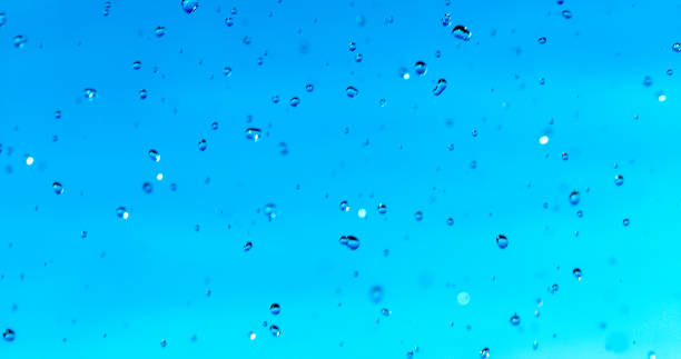 Water Droplets Hover in mid-air against a Blue Sky,Forming a Striking Contrast that Elegantly Highlights the Beauty of Nature's Fleeting Moments