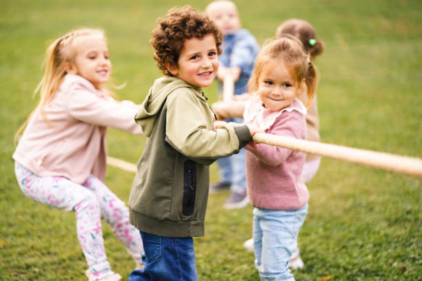 istock Group of children pulling a rope in public park 2176688668