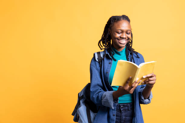 istock Radiant young girl reading interesting book, studio background 2176689270