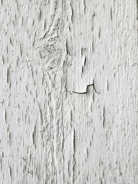 Cracked and peeling paint covers the surface revealing weathered wood underneath