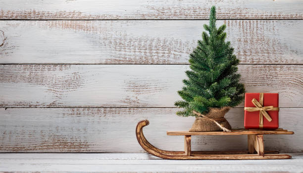 istock Festive Christmas Tree and Red Gift Box on Rustic Wooden Sled 2176692637
