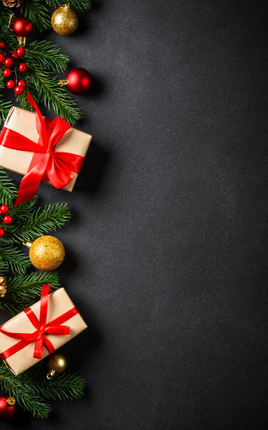 istock Christmas background with christmas tree, present box and holidays decorations at black. 2176692962