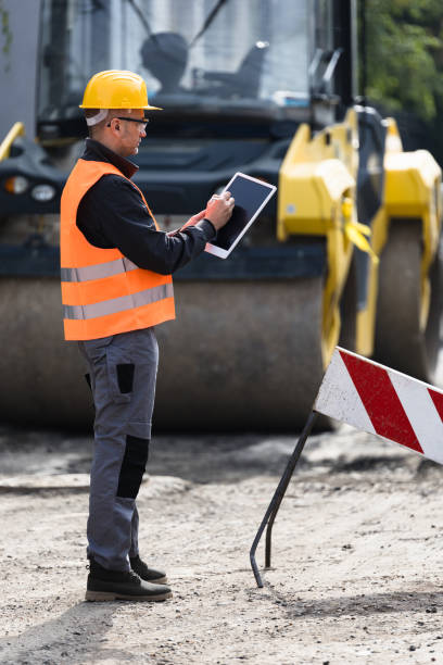 istock Construction manager assessing site conditions with a tablet while wearing safety gear near heavy machinery in the afternoon 2176695196