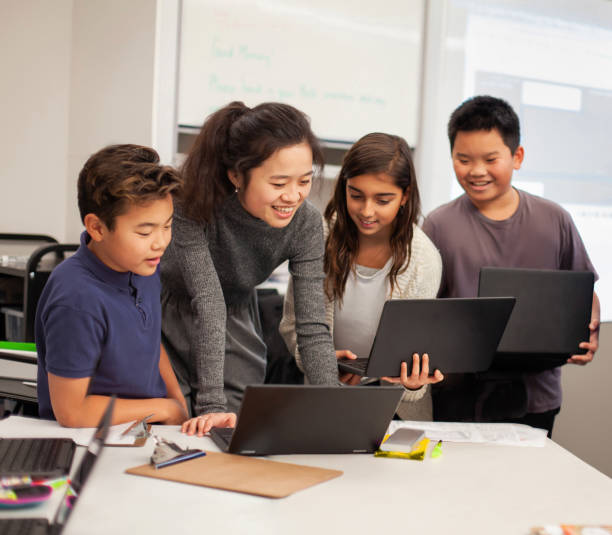 istock Asian Chinese teacher instructor teaches multiracial group of elementary school students using laptop in classroom 2176704857