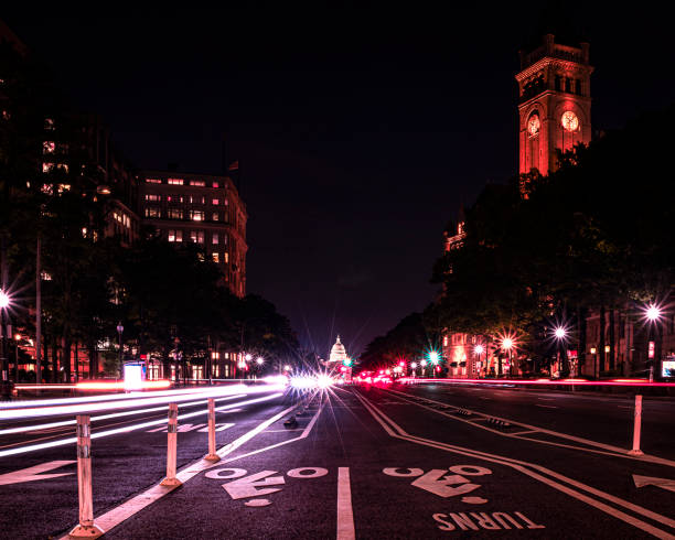U.S. Capitol Building and Old Post Office Tower at night from Pennsylvania Avenue with light streaks from traffic