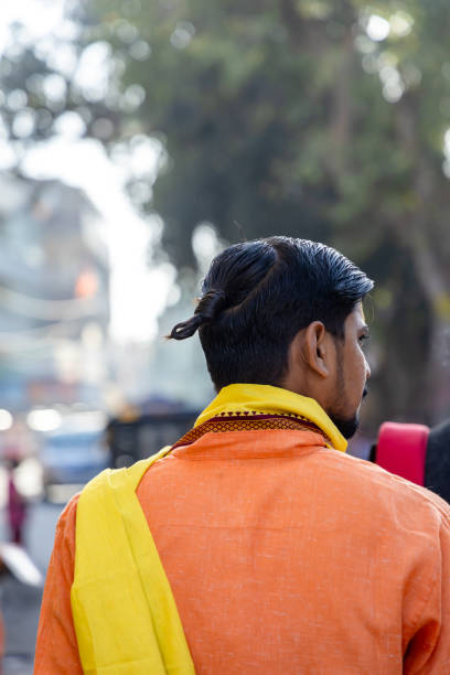 Hindu Brahmin Devotee with Hair Tied in Knot or Braid from Back in Morning image is taken at shipra river ujjain madhya pradesh india on Mar 09 2024.